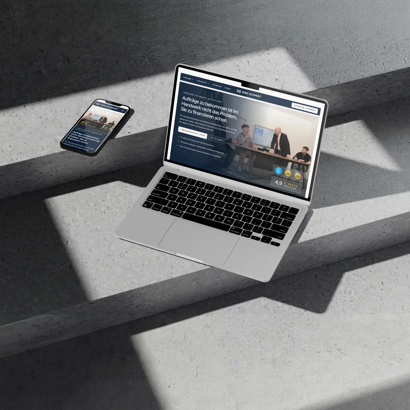 Von newcreation gestaltete Webseite der Schmidt Unternehmensberatung für Finanzierung im Handwerk auf MacBook und iPhone auf Betonstufen